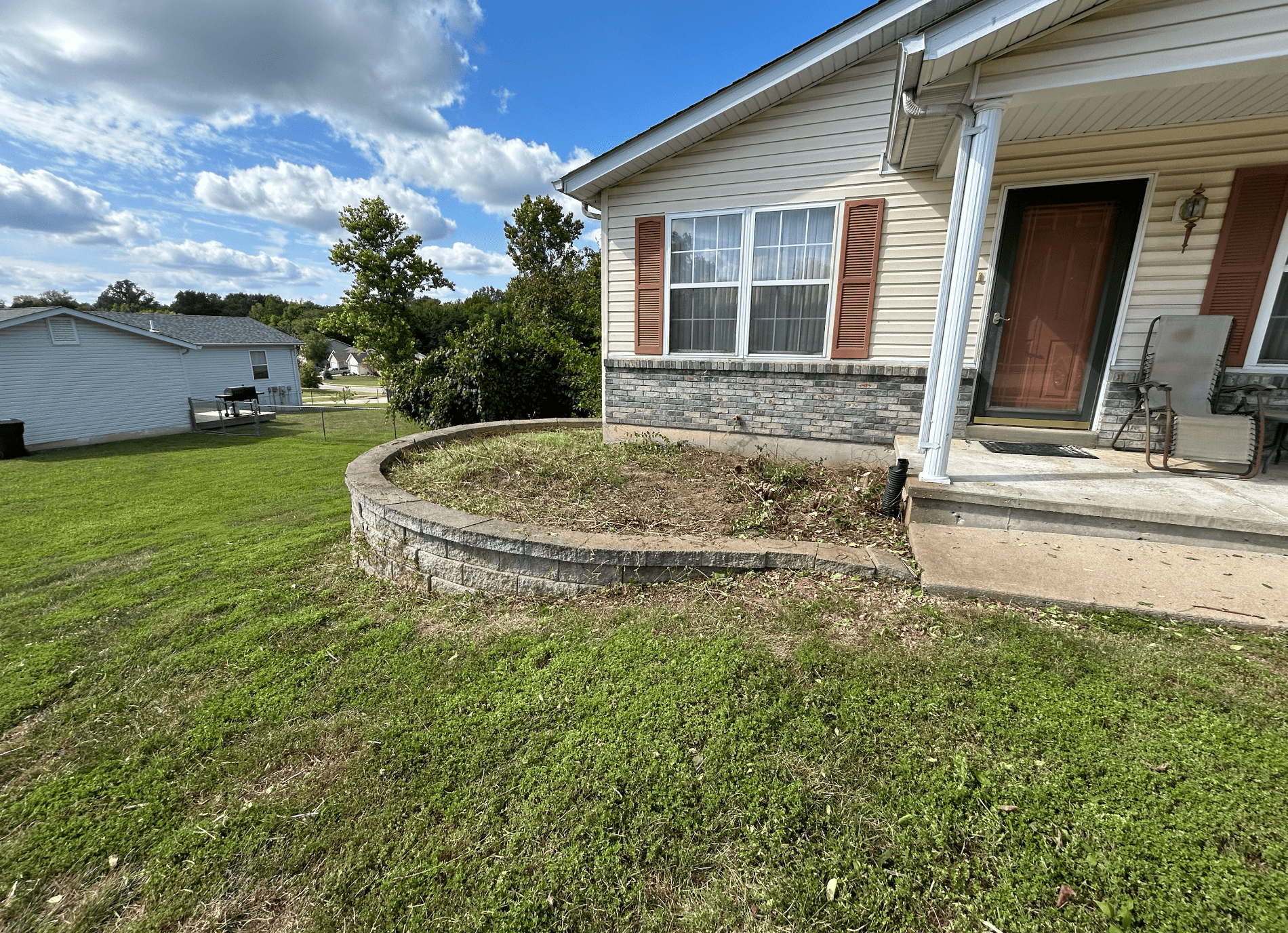 Landscape bed after large bush removal, showing the front yard opened up and cleared